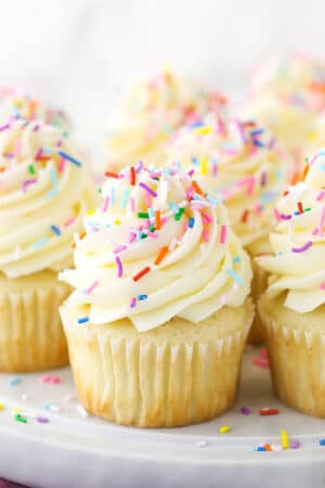 vanilla cupcakes with sprinkles on marble platter