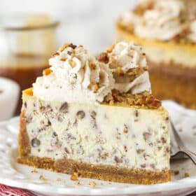 A slice of brown butter pecan cheesecake on a white plate