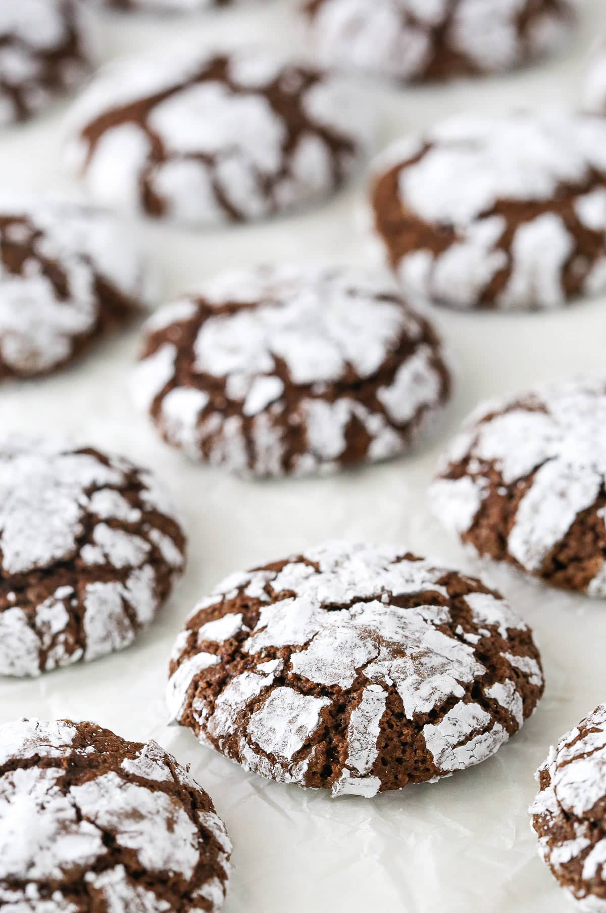 Chocolate crinkle cookies on a white surface.