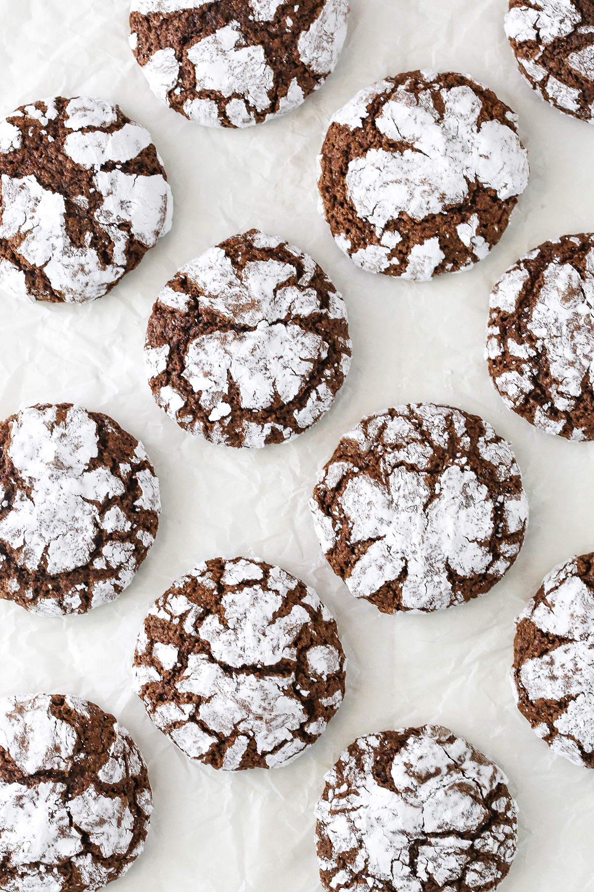 Chocolate crinkle cookies on a white surface.