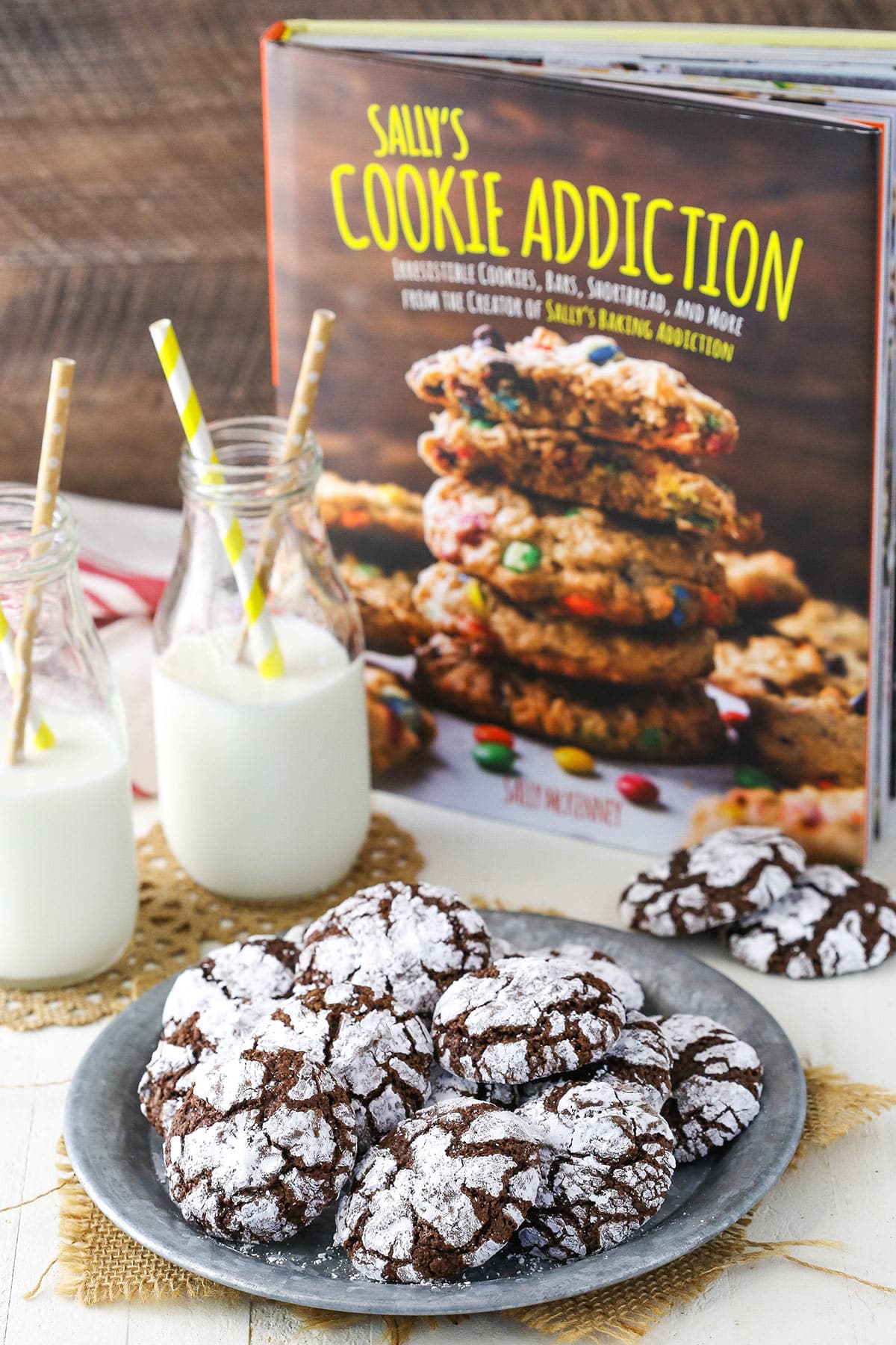 Chocolate crinkle cookies on a plate with a cookbook in the background.