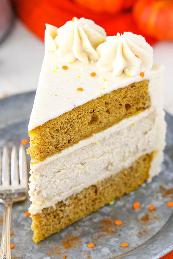 Slice of pumpkin cheesecake cake with cream cheese frosting.