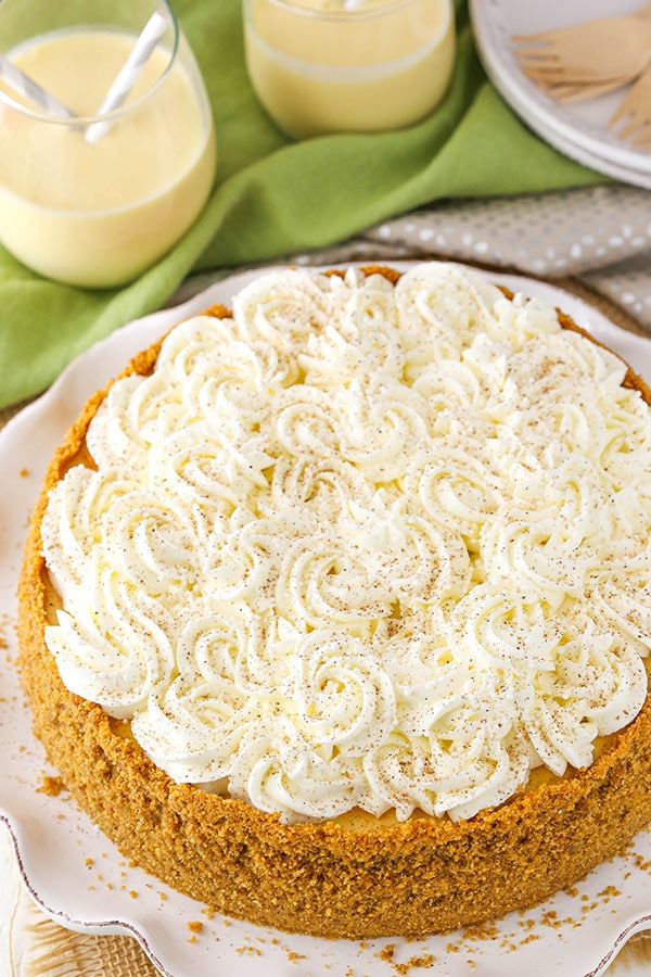 Eggnog cheesecake with swirls of whipped cream on top.