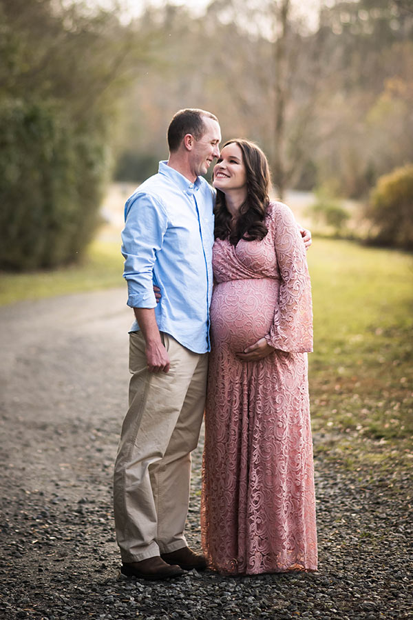 My Husband and I Hugging as I Hold my Stomach