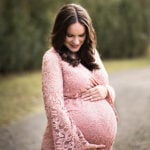 Lindsay Standing in a Pink Dress, Looking Down at her Stomach