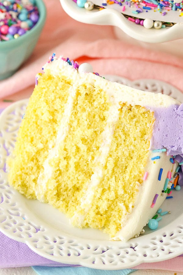 A slice of vanilla layer cake with frosting