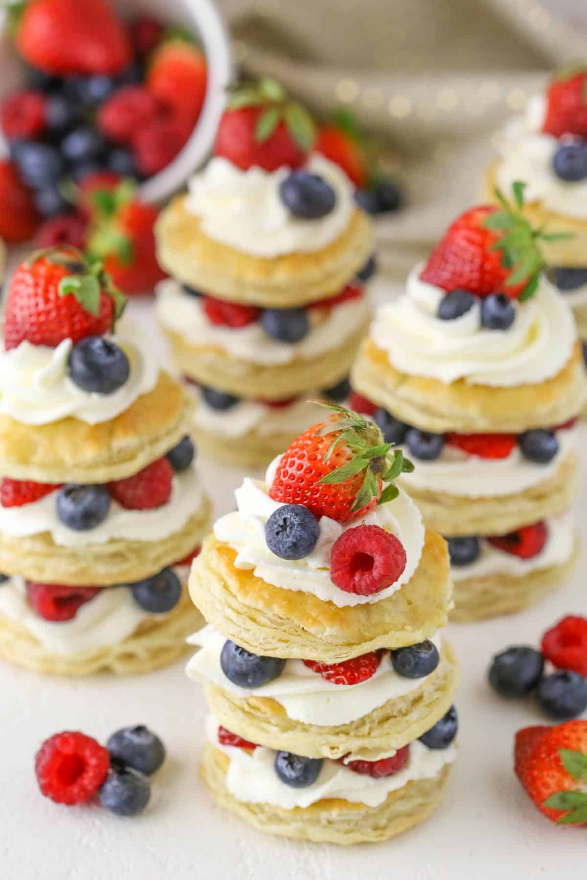 Several stacked mini berries and cream puff pastry cakes. 