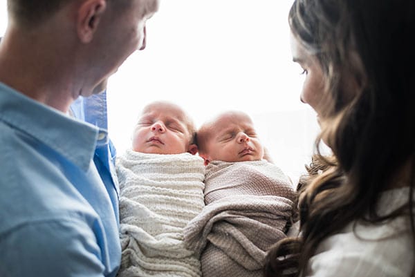 Ashton and Brooks Being Swaddled and Held by My Husband and Me