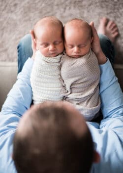 My Husband Holding Ashton and Brooks on His Lap While They're Swaddled
