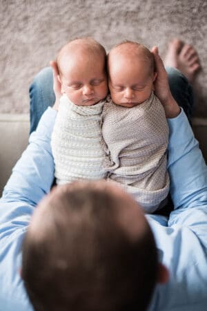 My Husband Holding Ashton and Brooks on His Lap While They're Swaddled