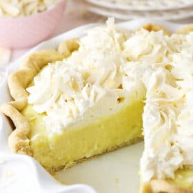 Coconut cream pie with a slice taken out of it.