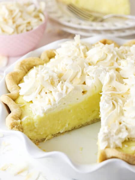 Coconut cream pie with a slice taken out of it.