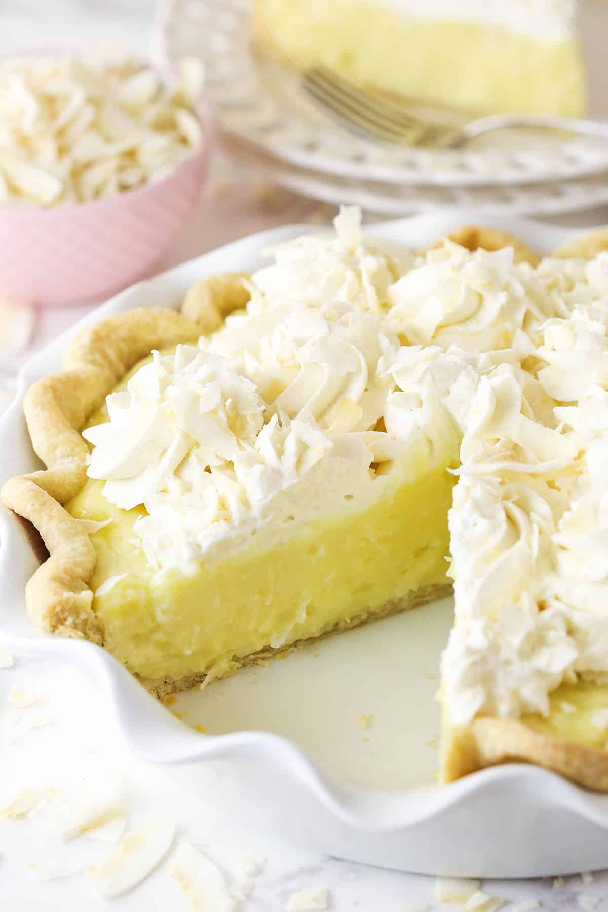 Coconut cream pie with a slice taken out of it.