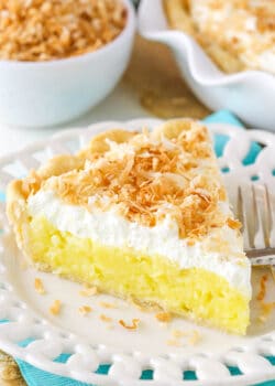 Slice of coconut cream pie with whipped cream and toasted coconut.