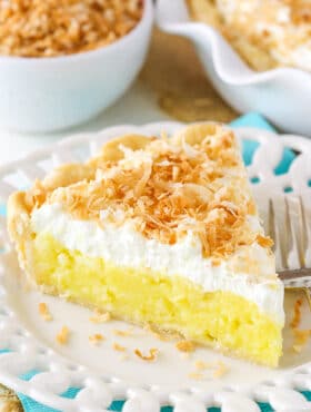 Slice of coconut cream pie with whipped cream and toasted coconut.