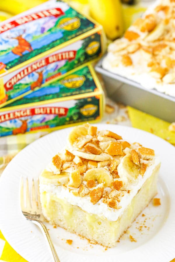 Banana Pudding Poke Cake slice with Challenge butter in background
