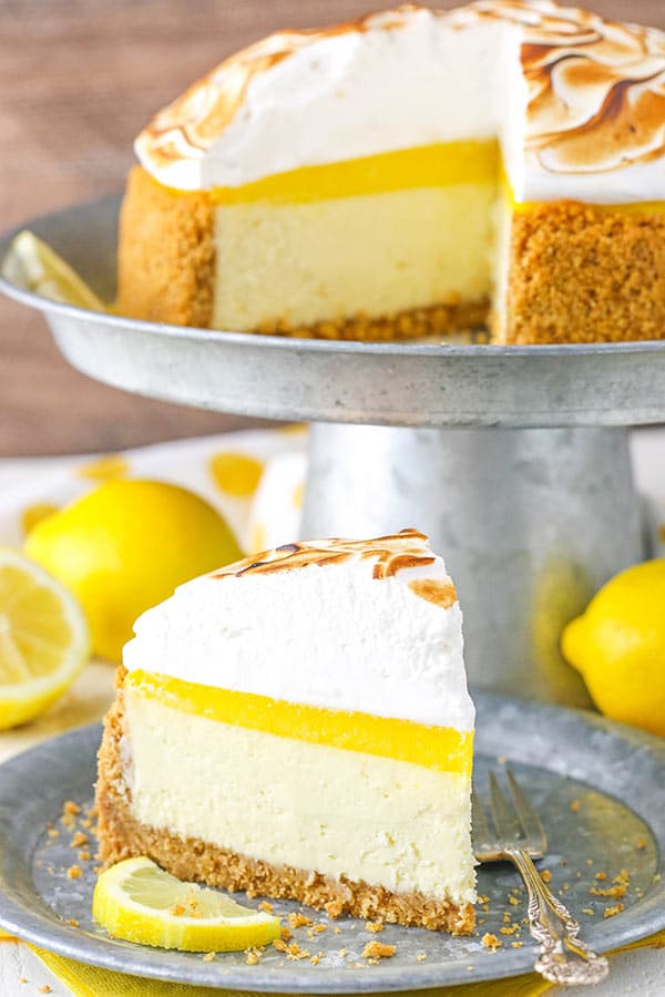 slice of Lemon Meringue Cheesecake on plate with cheesecake in background