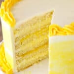 A Lemon Curd Layer Cake on a White Stand with a Slice Removed