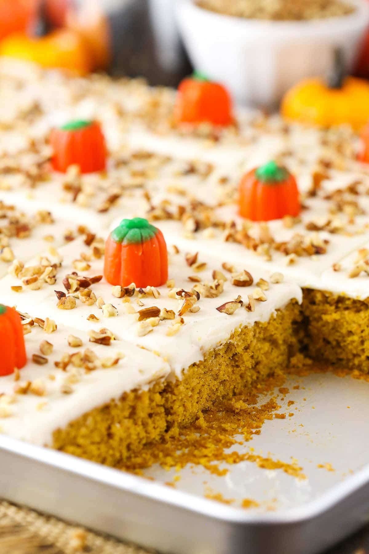 Pumpkin sheet cake in a tray. Two slices are missing.