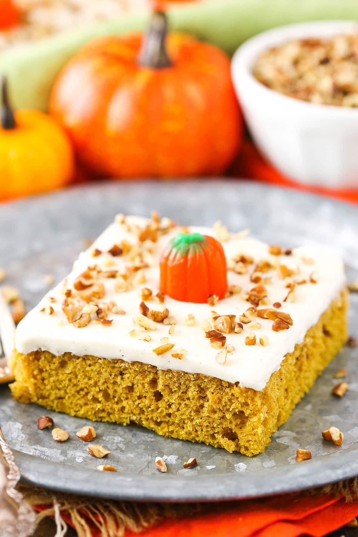 Slice of pumpkin sheet cake with cream cheese frosting on a plate.