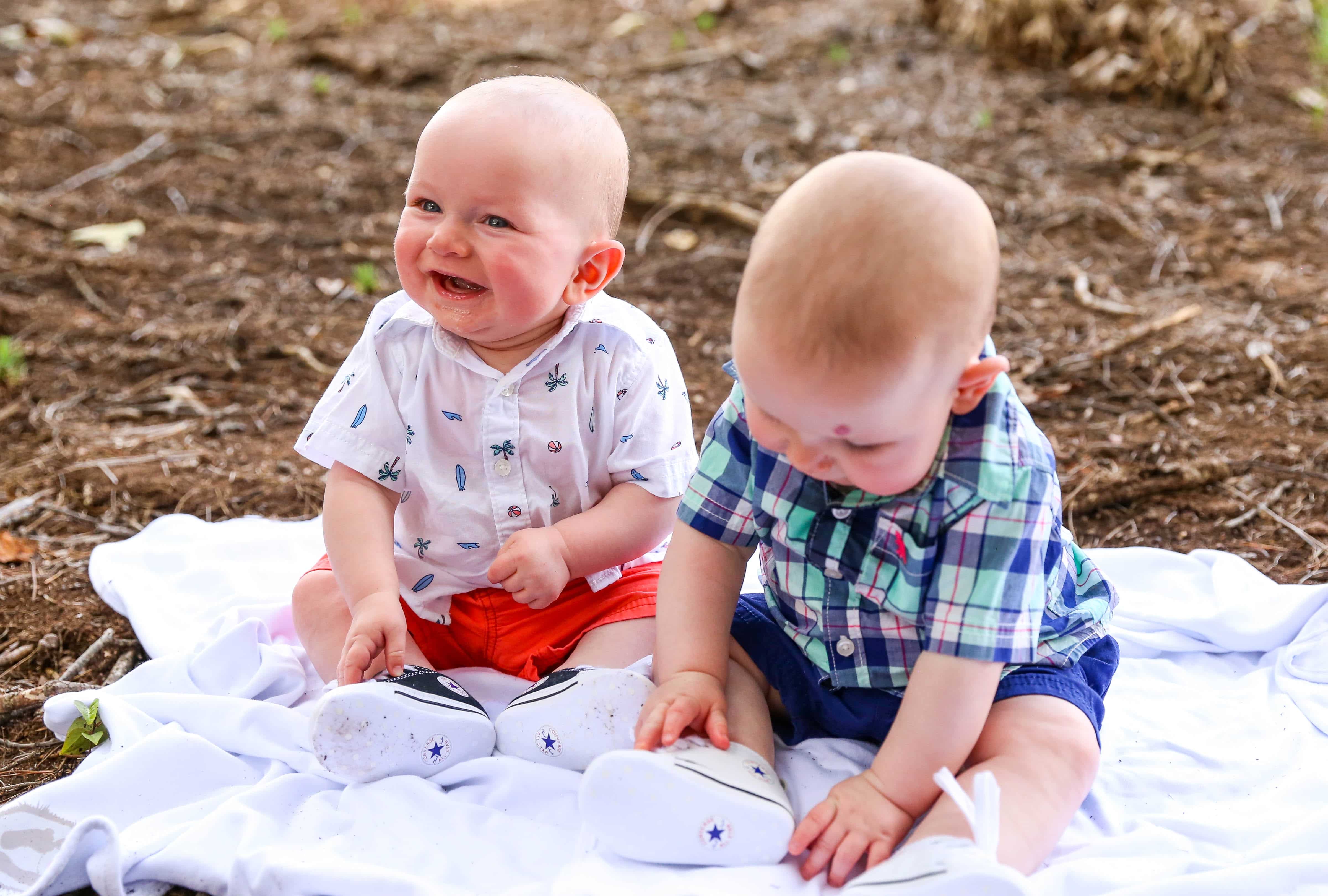 twins sitting on ground, ashton smiling