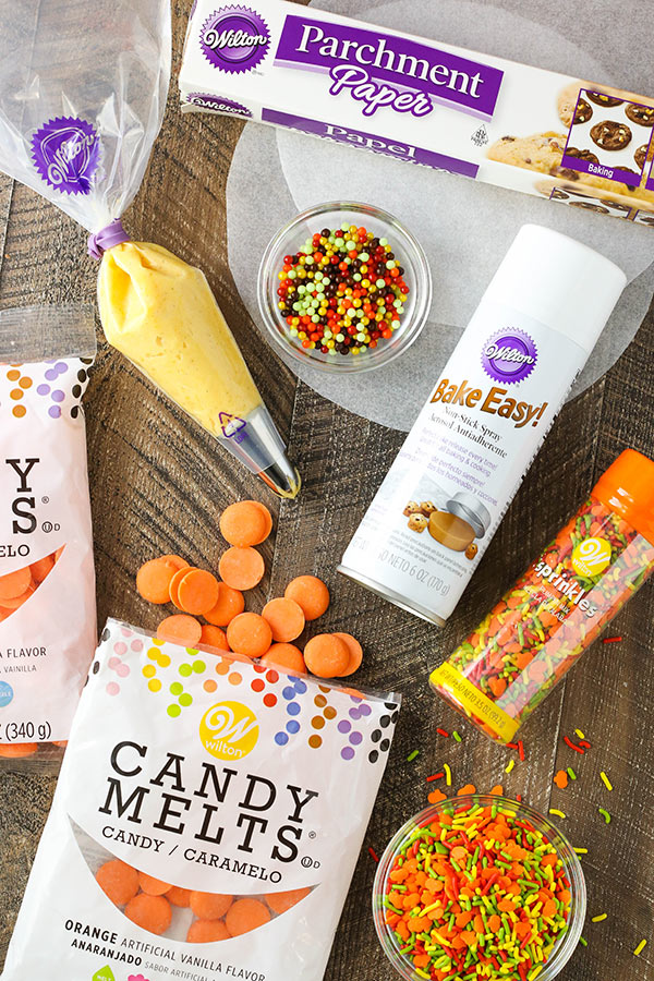 Overhead shot of baking tools-parchment circles, baking spray, frosting bags, sprinkles.