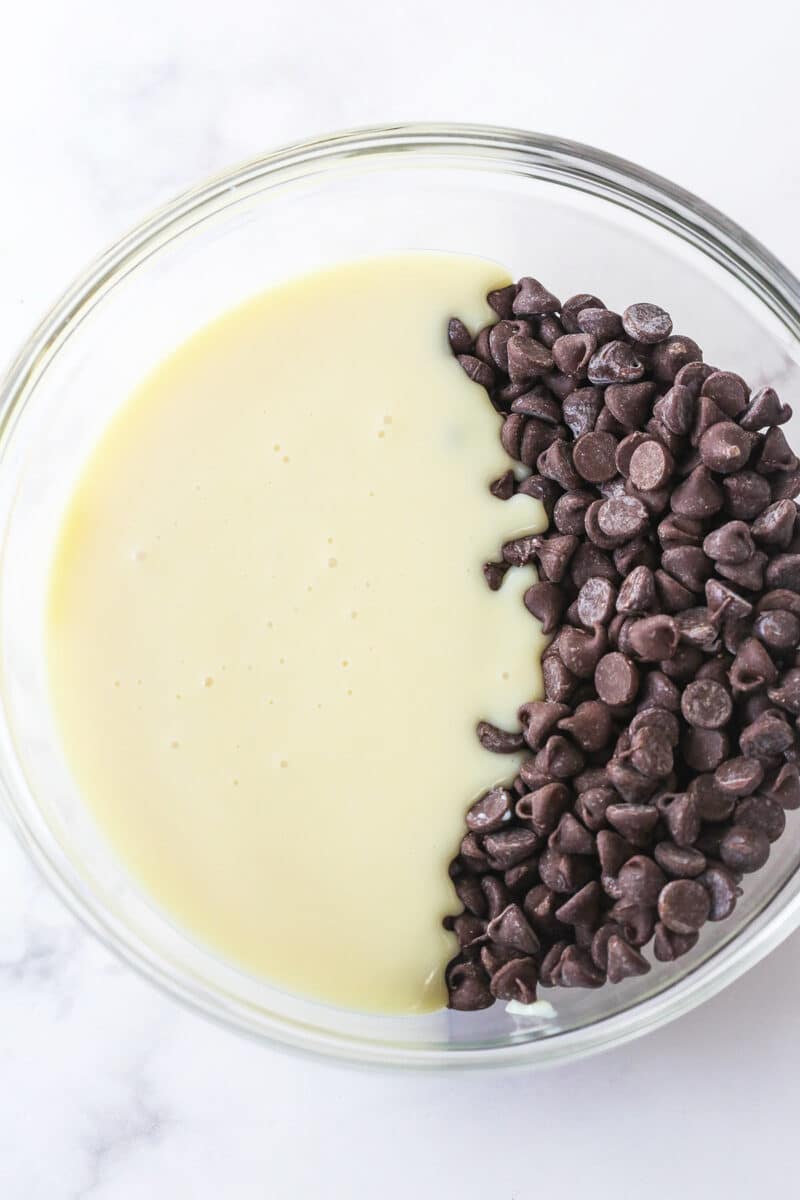 Sweetened condensed milk and chocolate chips in a bowl