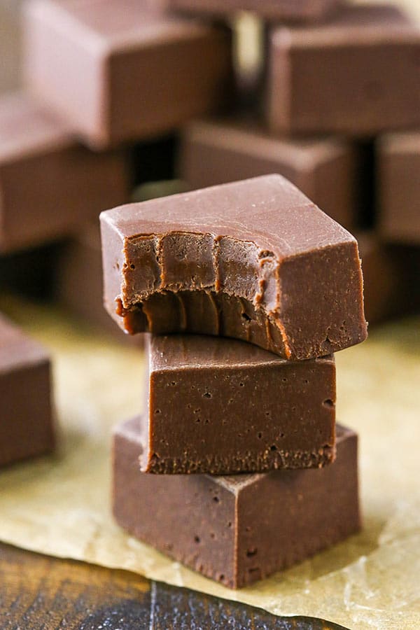 A stack of homemade chocolate fudge pieces with a bite taken out.