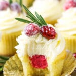 A sparkling cranberry white chocolate cupcake with a bite taken out to reveal the mascarpone filling