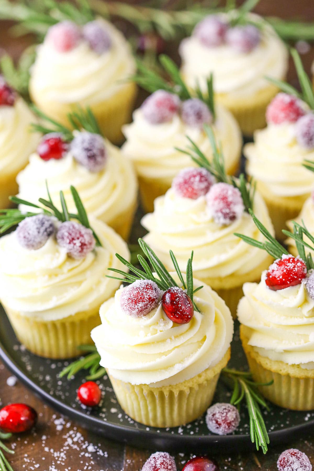 A bunch of cranberry white chocolate cupcakes on a large round serving platter