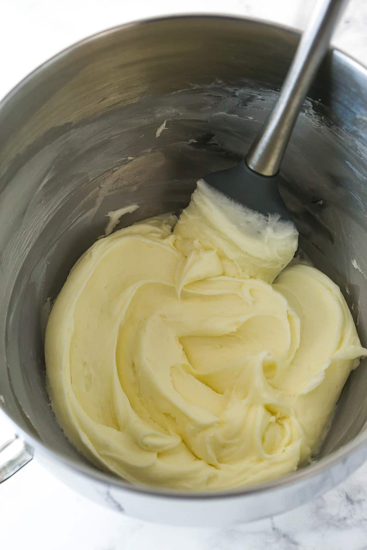 cream cheese frosting in a metal mixing bowl