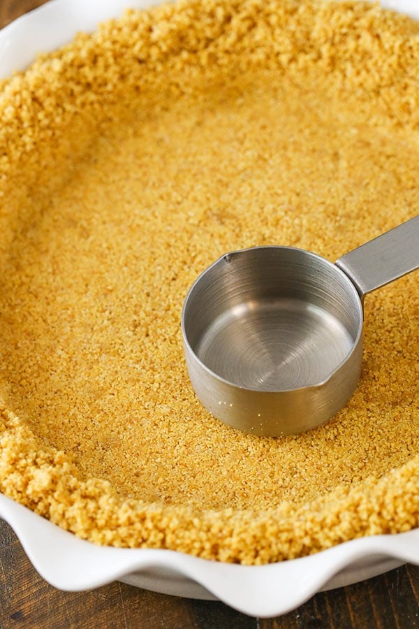 This graham cracker crust is easy to make and delicious, made with scratch from only four ingredients! It won't fall apart and it's perfect for baked pies, no bake pies and cheesecakes!