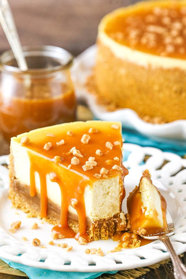 A slice of cheesecake topped with caramel with a fork full taken out.