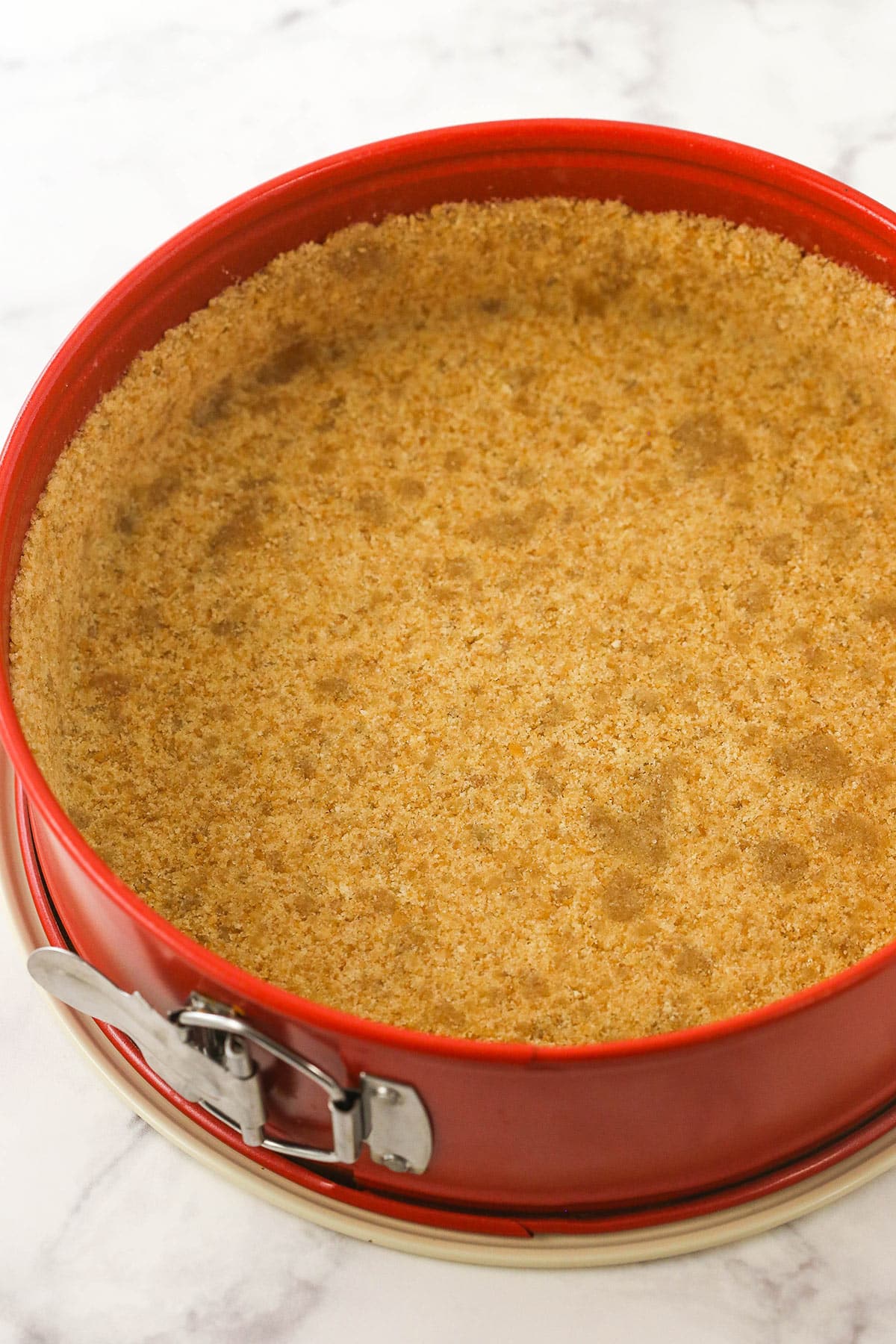 Graham cracker pie frust in a springform pan ready to bake