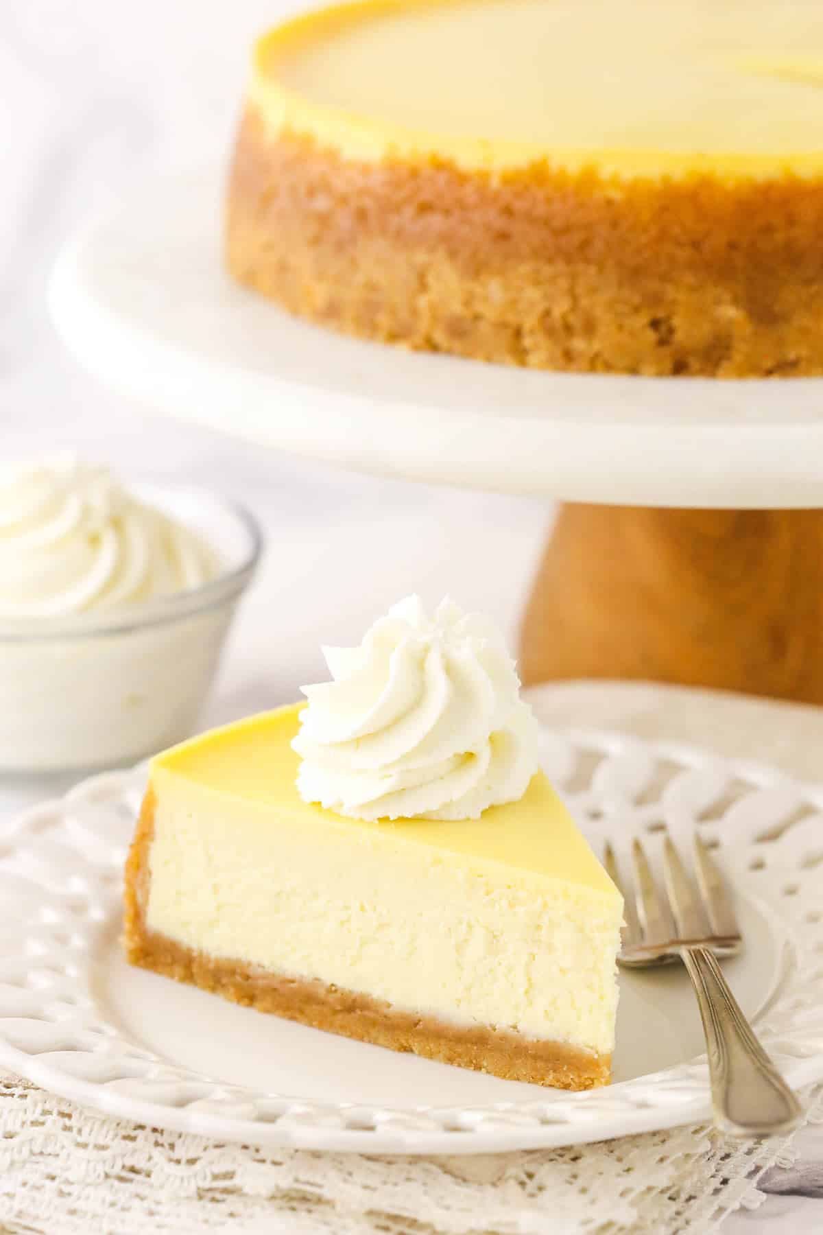 A slice of cheesecake with a dollop of whipped cream