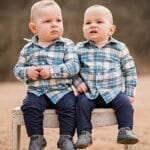 twins on a bench in a field