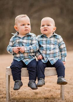 twins on a bench in a field