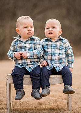 twins on a bench in a field