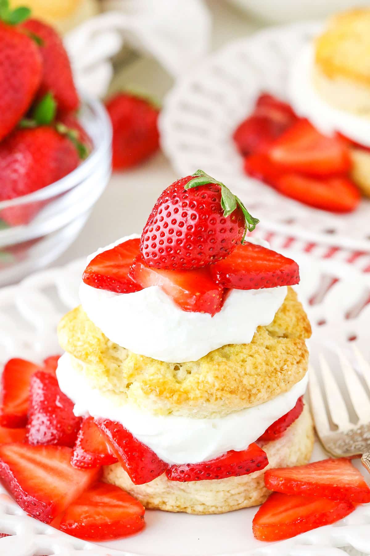 Strawberry shortcake on a plate with homemade whipped cream.