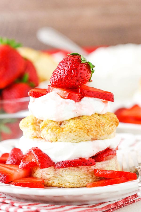Strawberry Shortcake on a plate with homemade shortcake biscuits, juicy strawberries and homemade whipped cream!