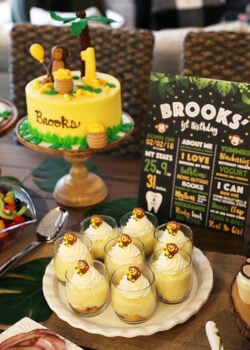 Eight Servings of Banana Pudding on a Serving Platter Next to a Banana Monkey Birthday Cake