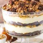 A close-up shot of a caramel cheesecake trifle on top of a striped cloth napkin