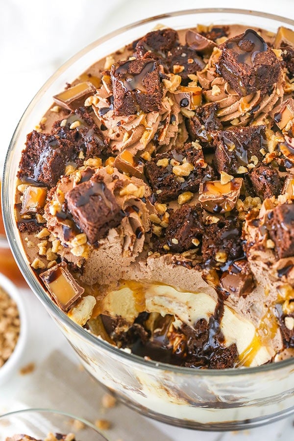 An overhead shot of a caramel cheesecake brownie trifle with one scoop removed