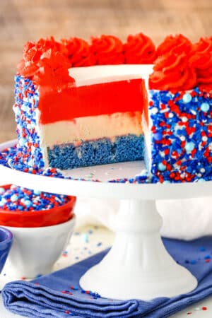 Red white and blue layer cake with sprinkles on the side.