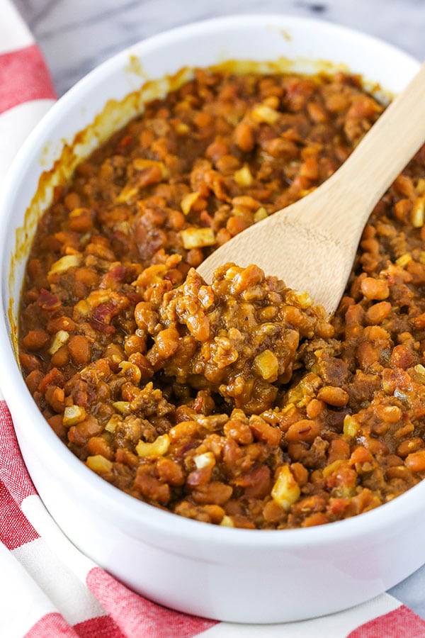 scooping some baked beans out of the dish