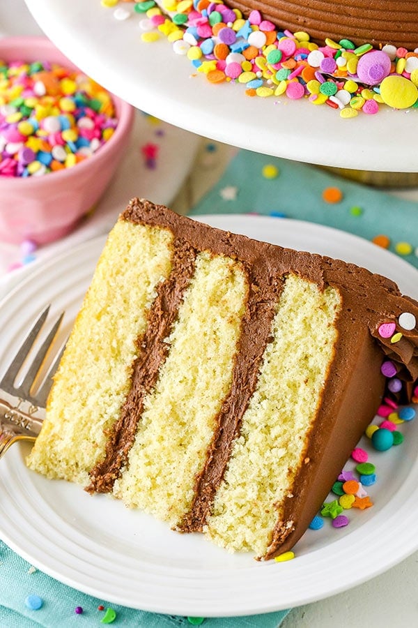 angled photo of a slice of yellow cake with chocolate frosting