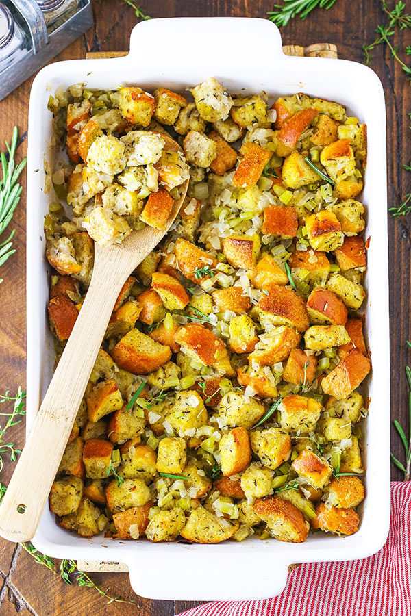A Pan of Thanksgiving Dressing with a Wooden Spoon Scooping Out a Small Portion