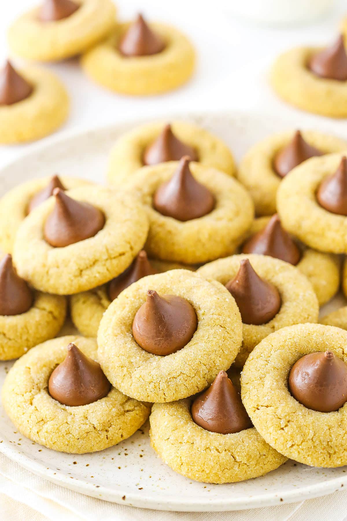 A white plate with a stack of classic peanut butter blossom cookies