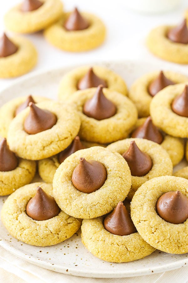 A white plate with a stack of classic peanut butter blossom cookies