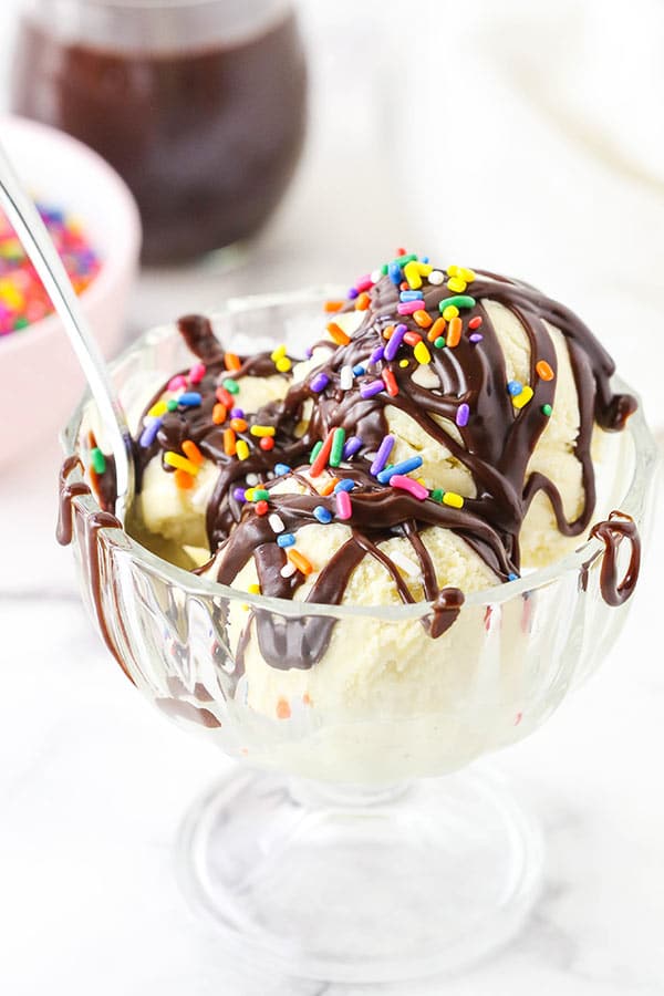 Easy Homemade Hot Fudge Sauce over ice cream with sprinkles